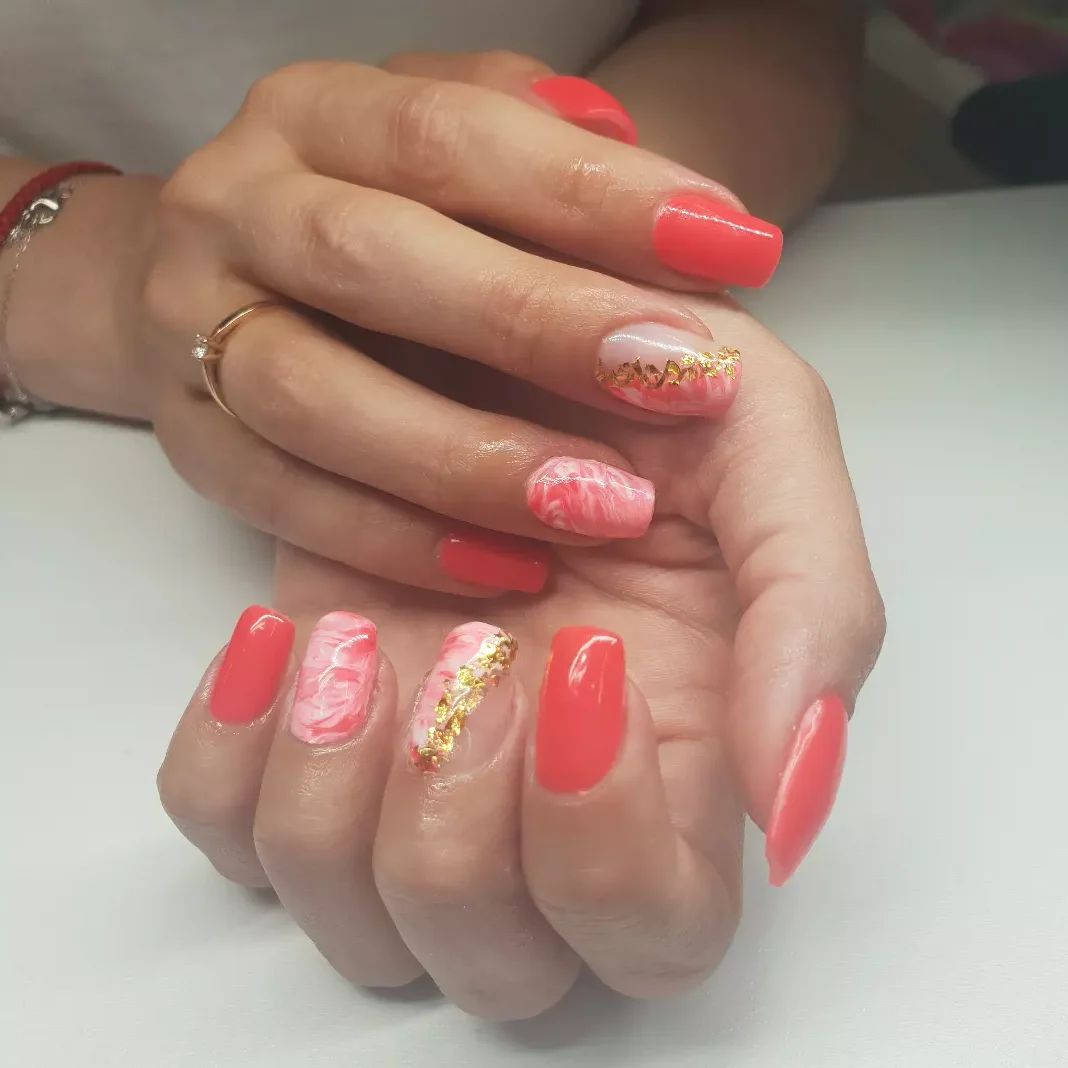 Manucure corail avec effet marbre et touches dorées